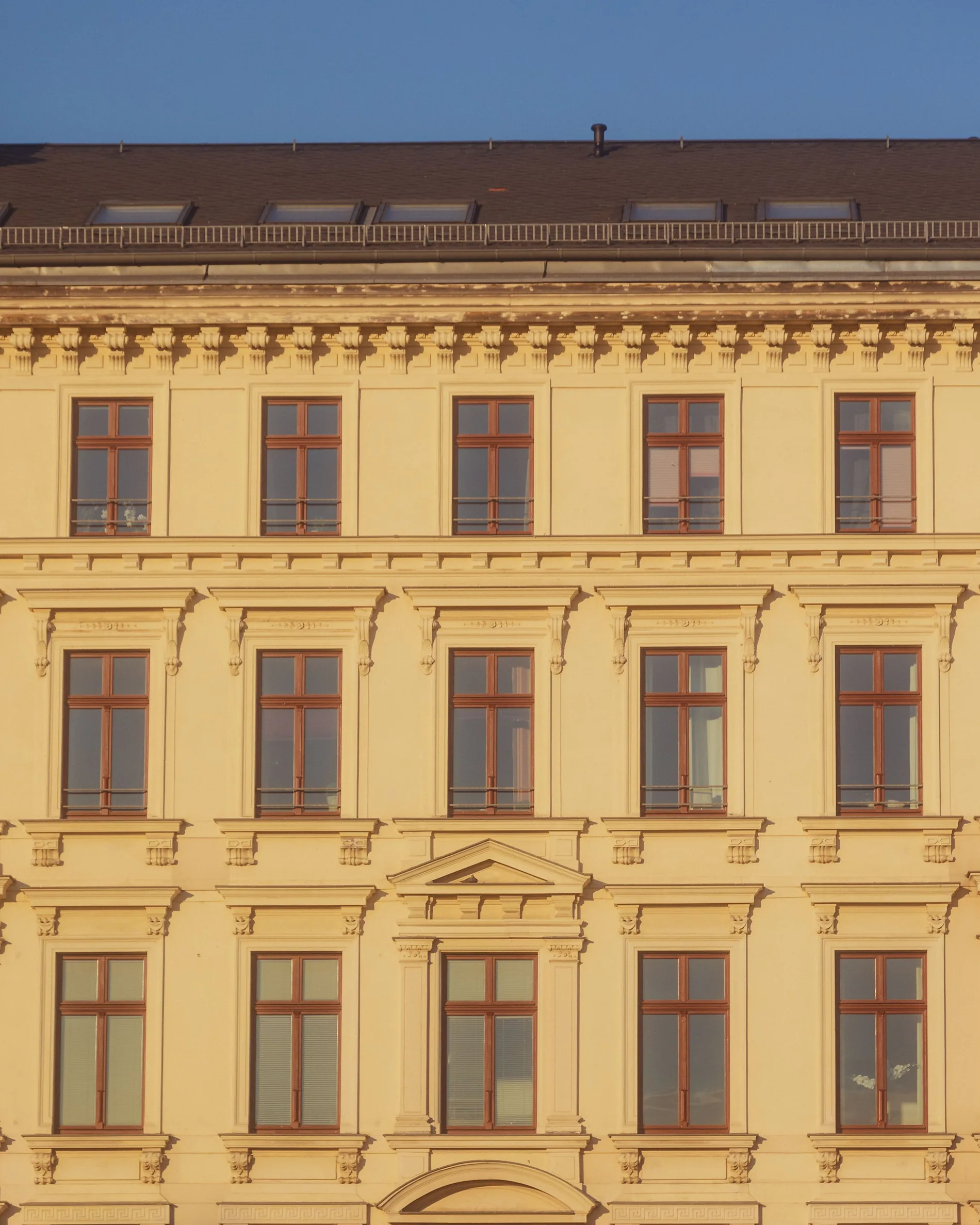 Helle historische Wiener Wohnhausfassade mit vielen Fenstern